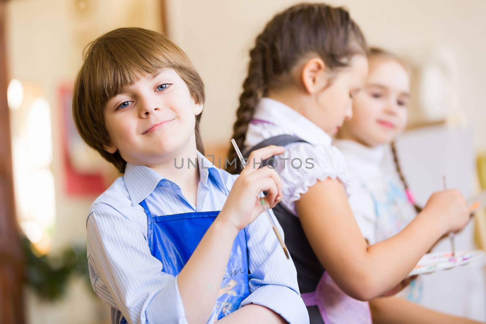 Little children painting and playing at kindergarten