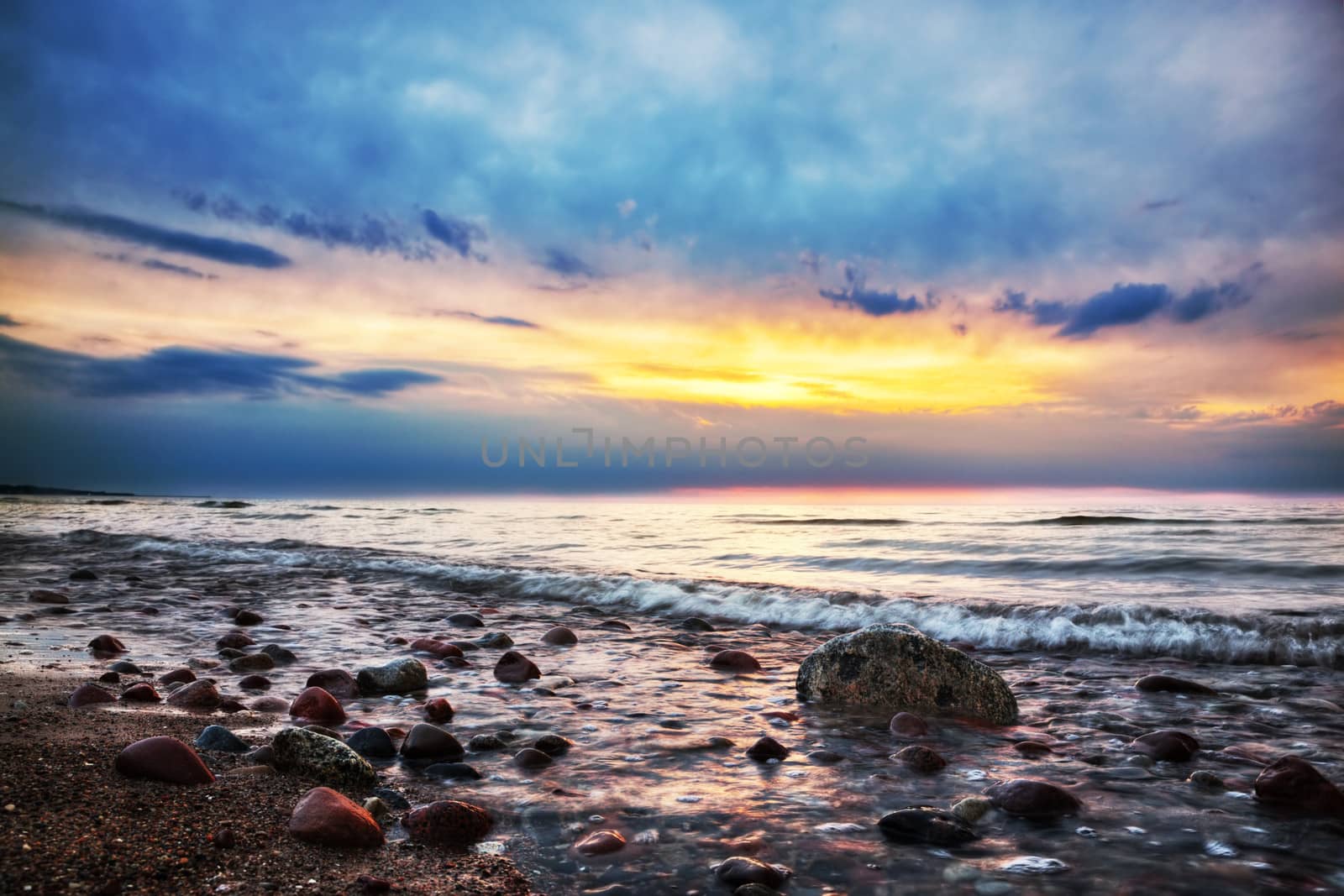 Dramatic sunrise on a rocky beach. Baltic sea by photocreo