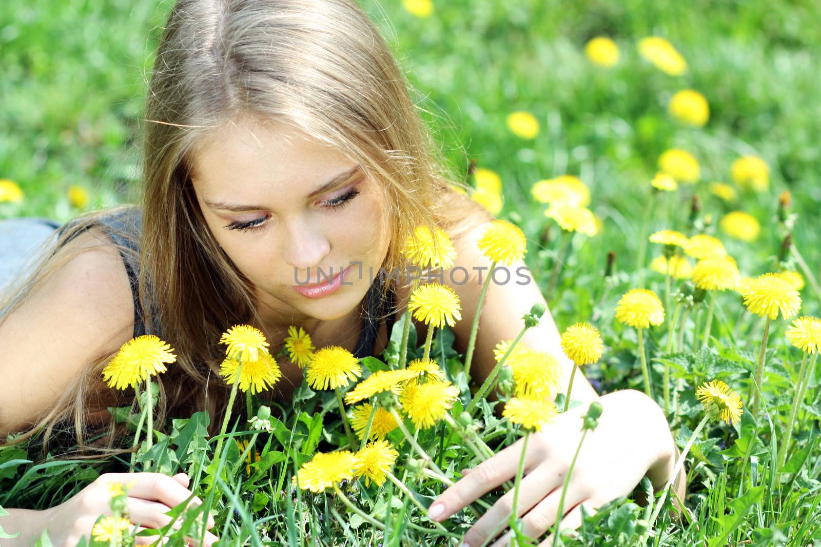 Young woman blows on a dandelion by andersonrise