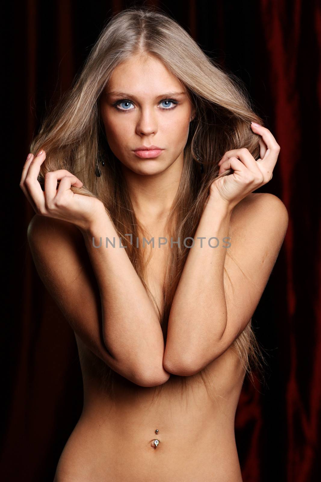 Sexy naked young woman in dark studio