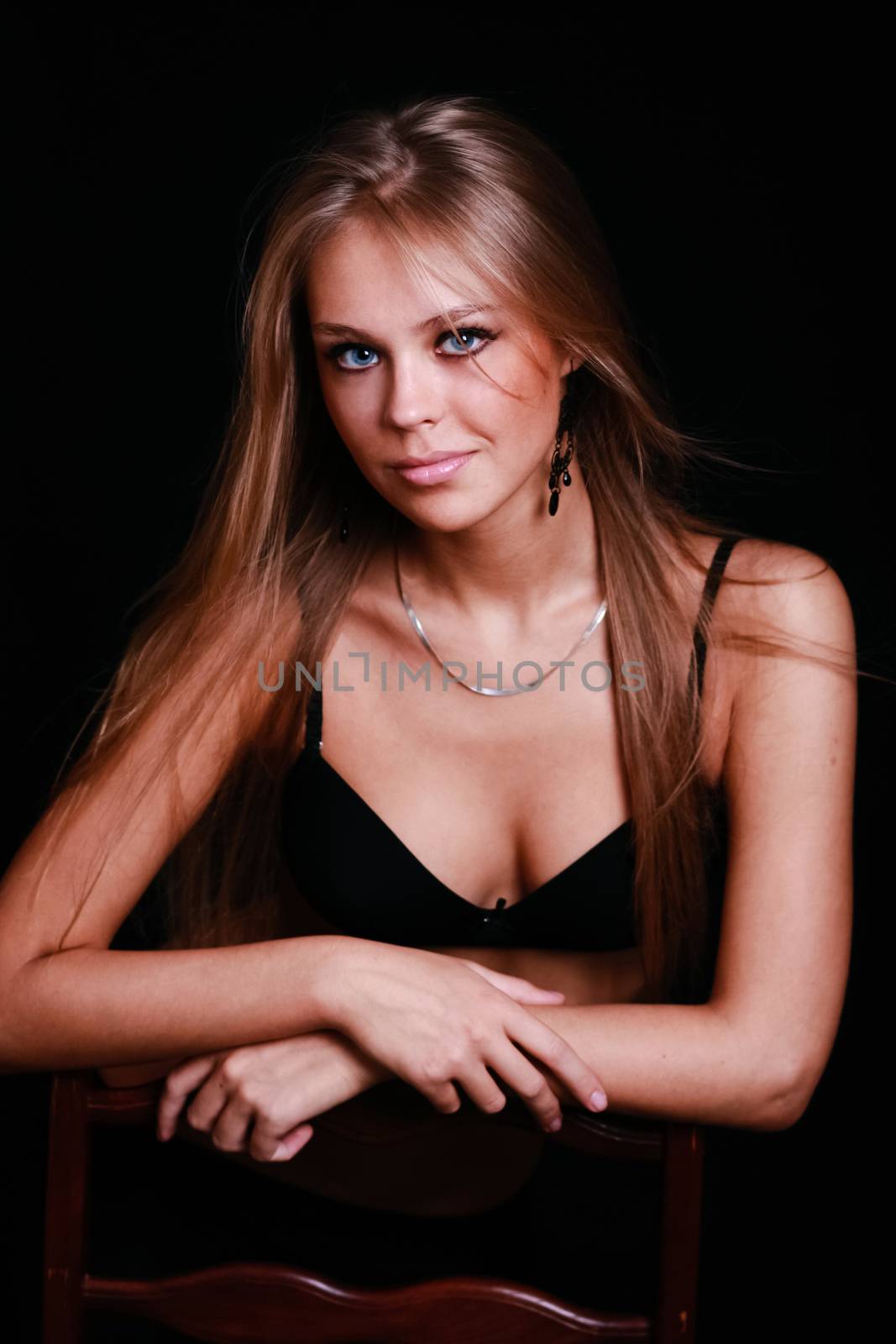 Sexy blond in black lingerie over dark background