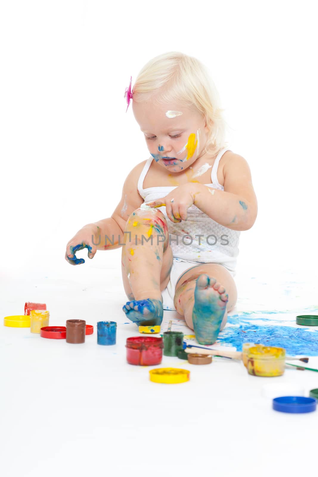 Little girl bedaubed with bright colors