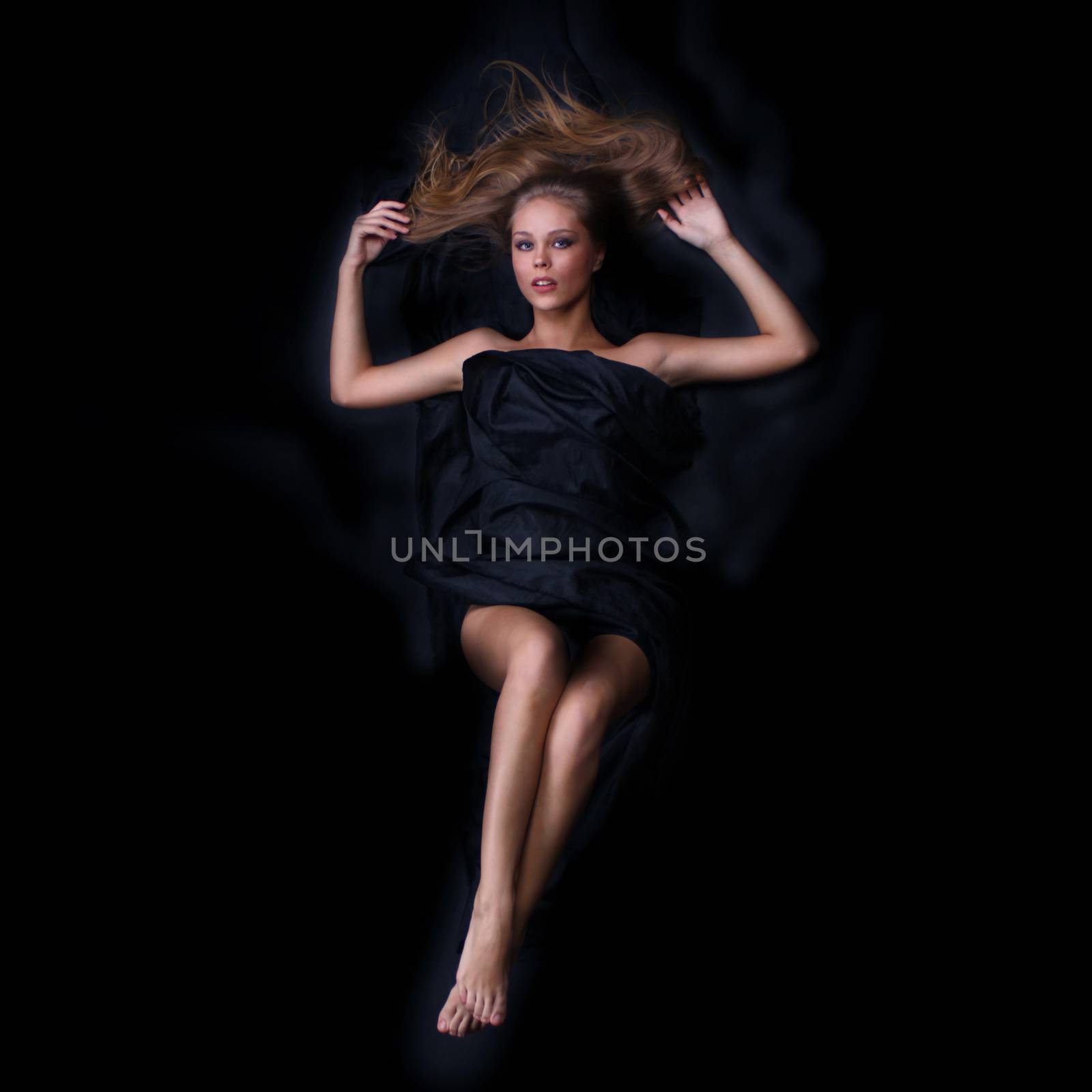 beautiful woman lies on black, the top view