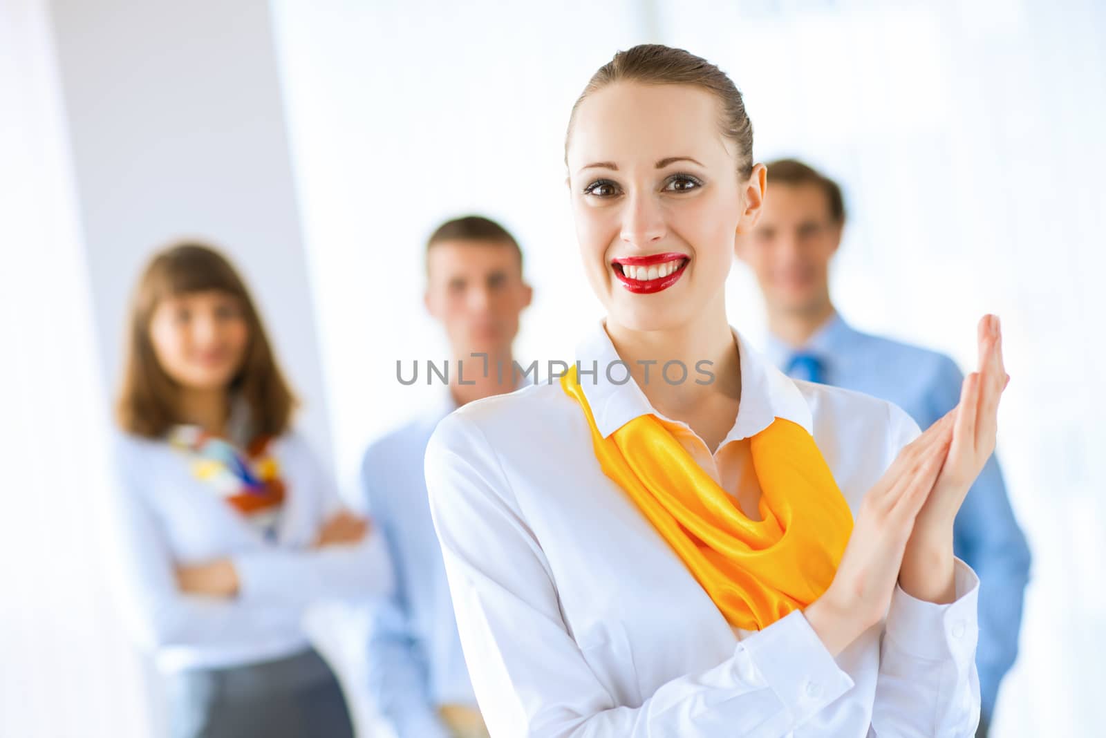 Portrait of a young successful business woman standing against colleagues