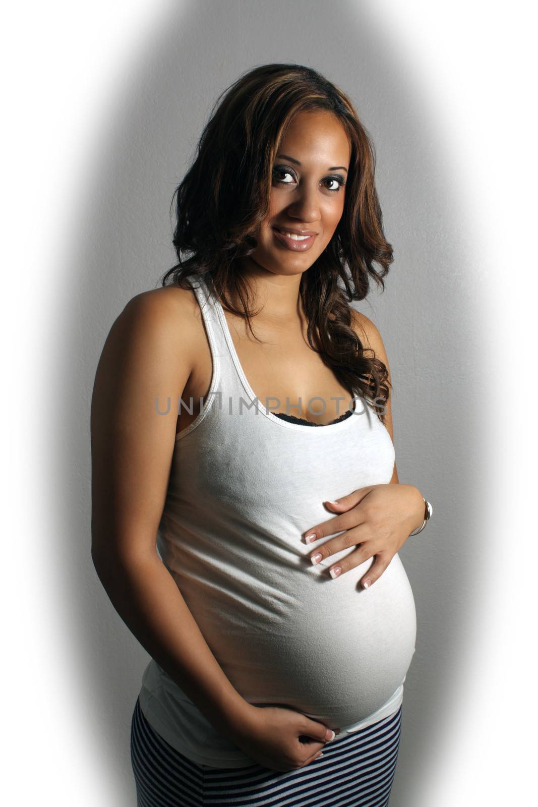 A lovely young multiracial woman, eight months pregnant.