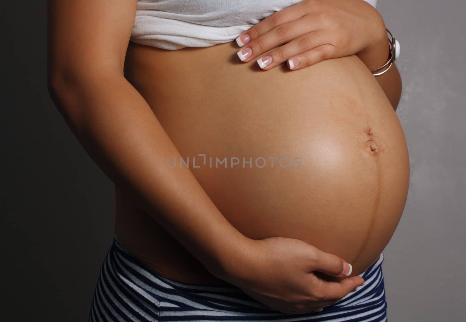 Close-up of the belly of an 8-month-pregnant woman.