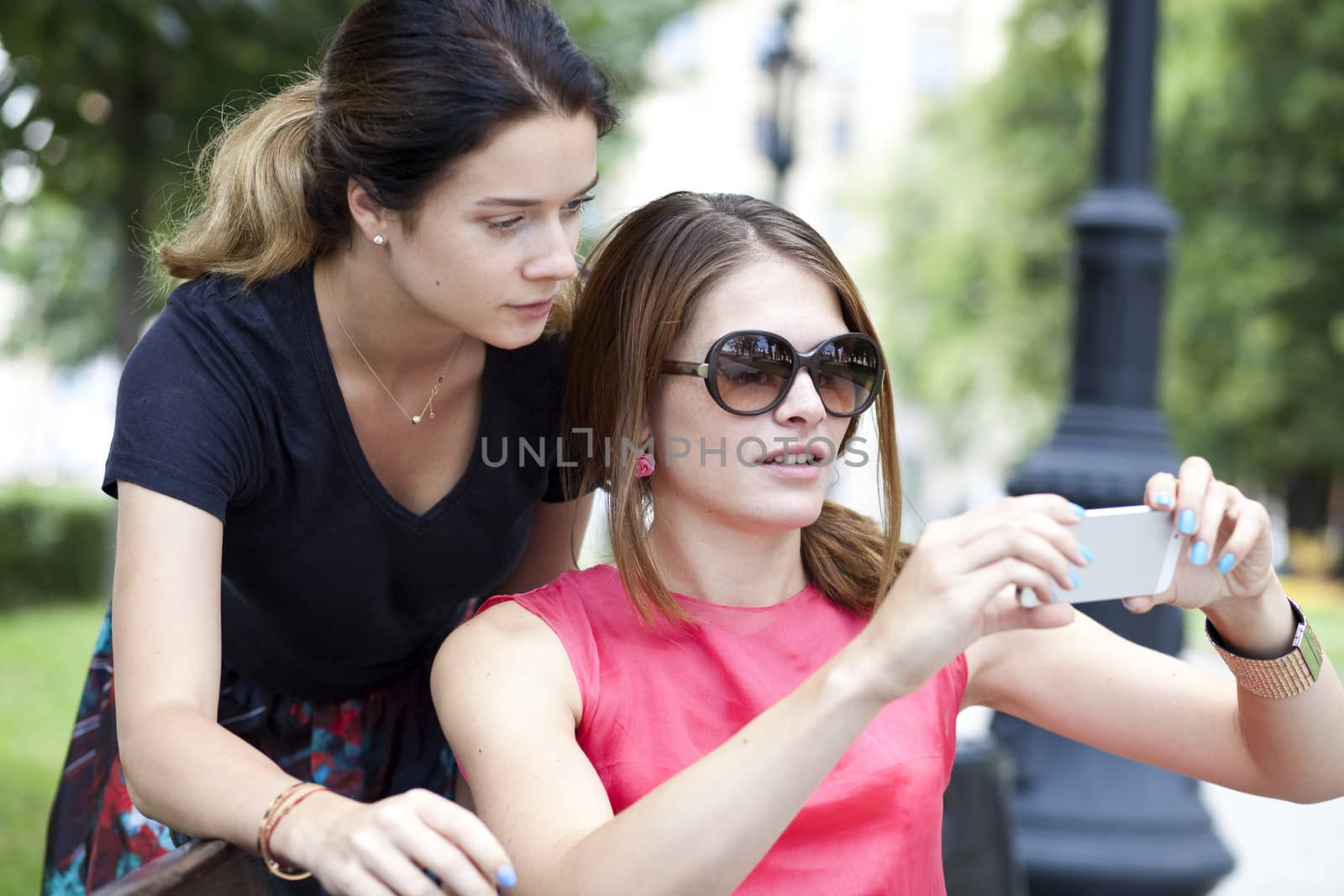 Happy young women taking pictures on your phone