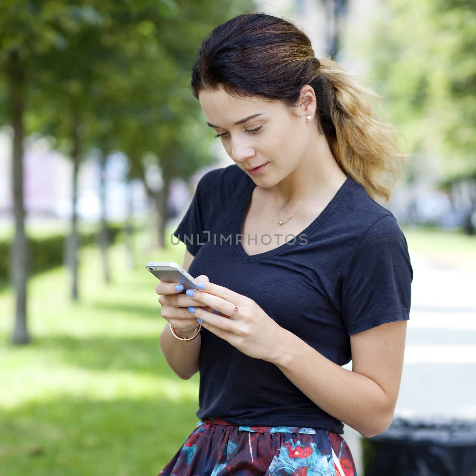 Young woman reading a message on the phone by andersonrise