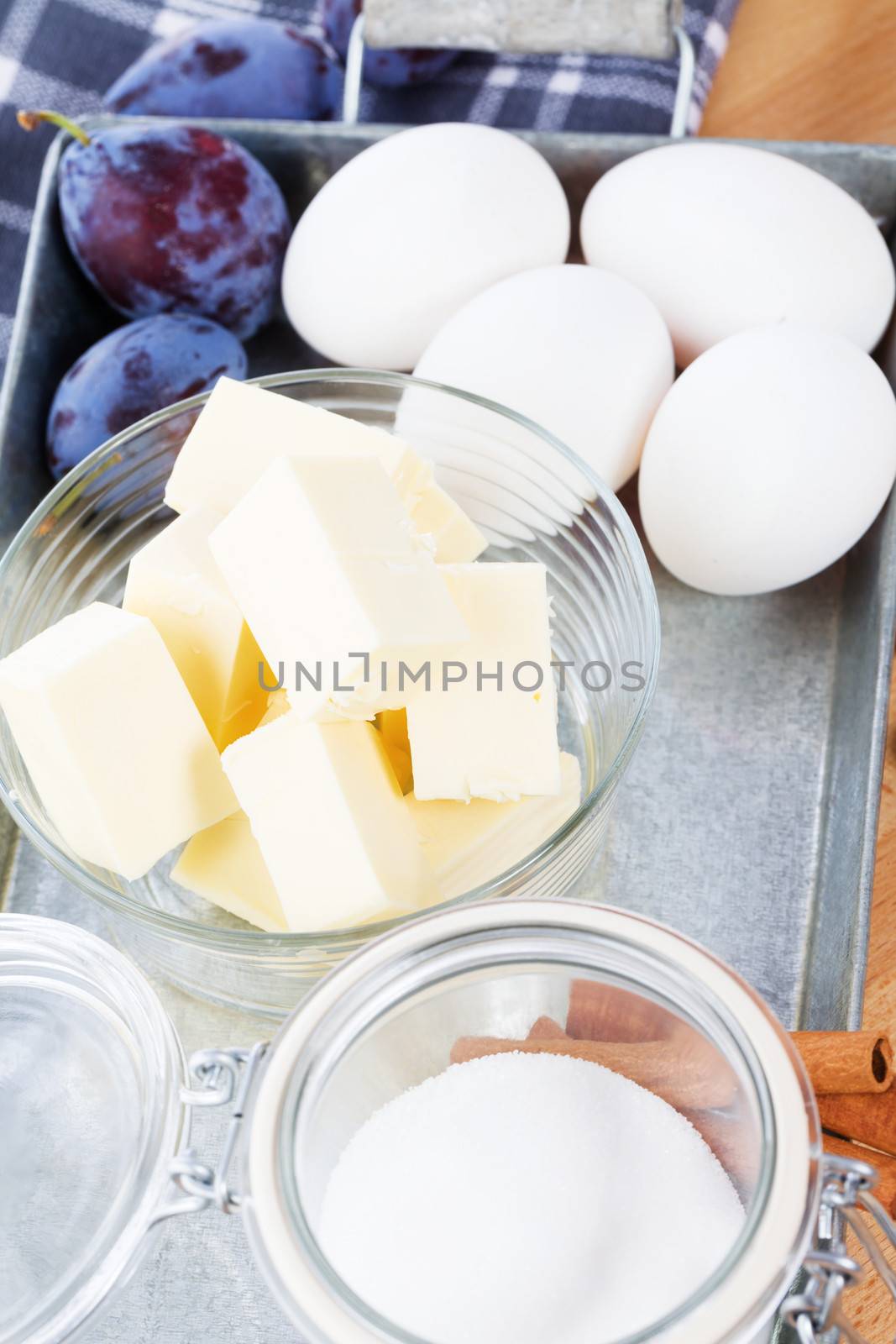 butter in a small glass bowl between baking ingredients on a metal tray