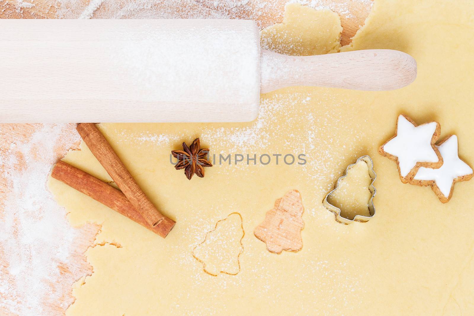 cutting out christmas shape cookies of dough from top 