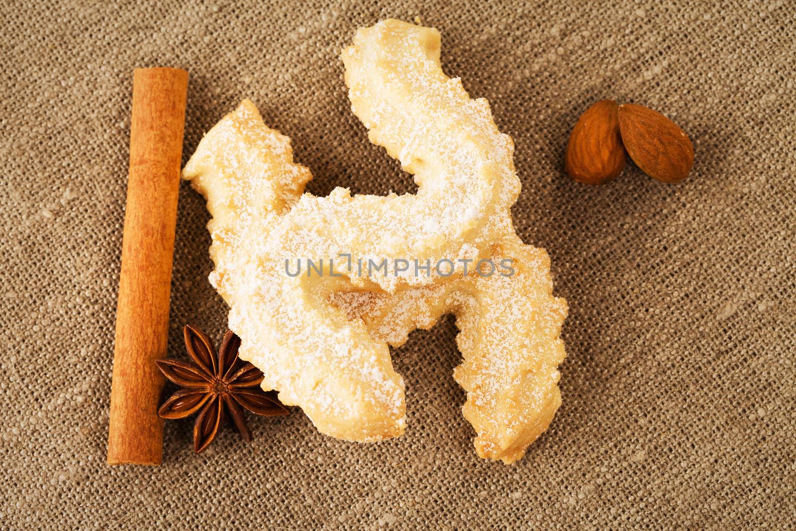 butter cookies with anise, cinnamon sticks and almonds from top on a fabric