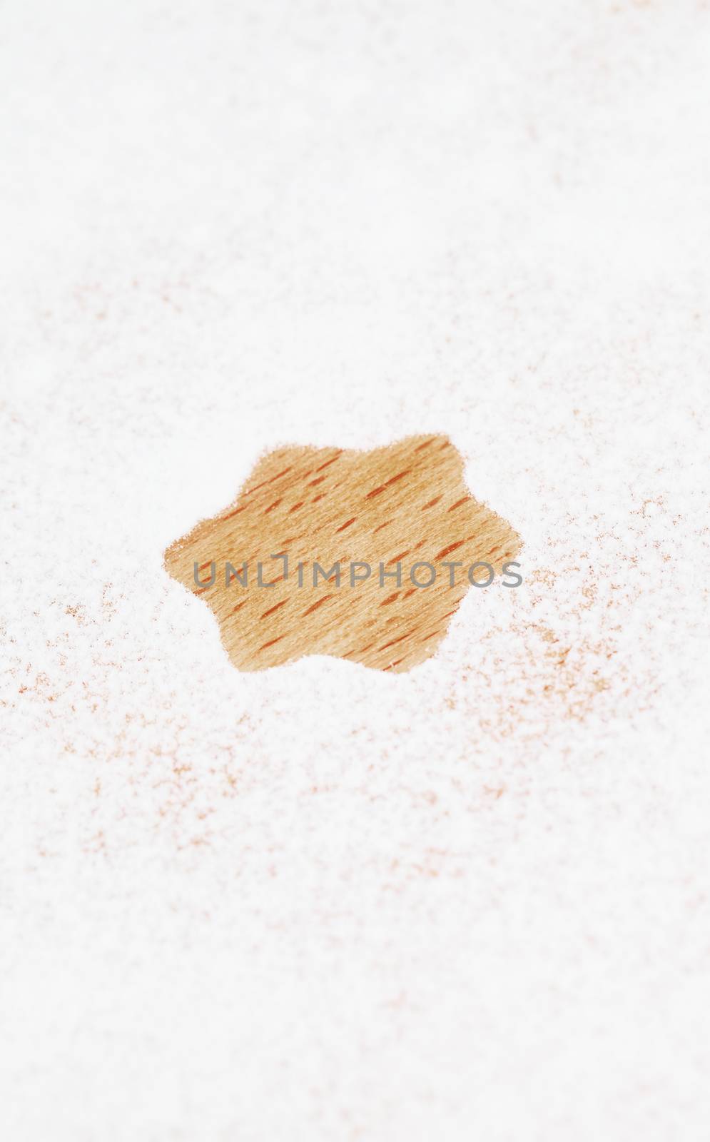 star shape spared out of white flour on wooden background