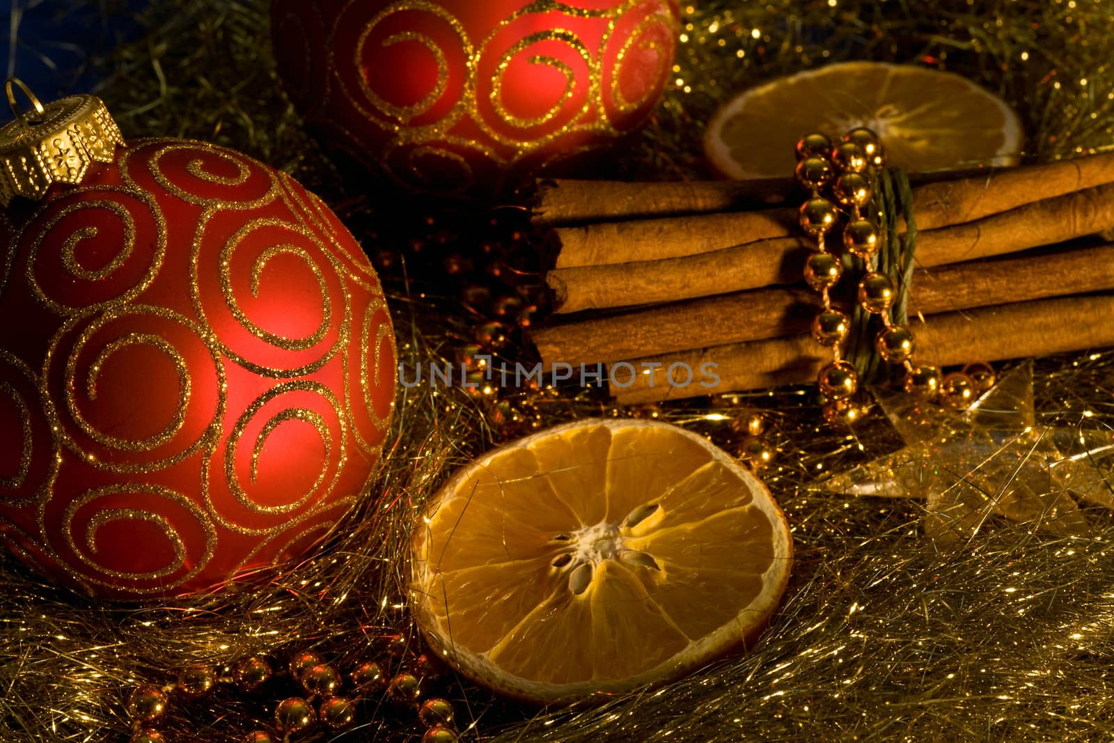 red christmas ball, cinnamon,   orange and beads on gold background 