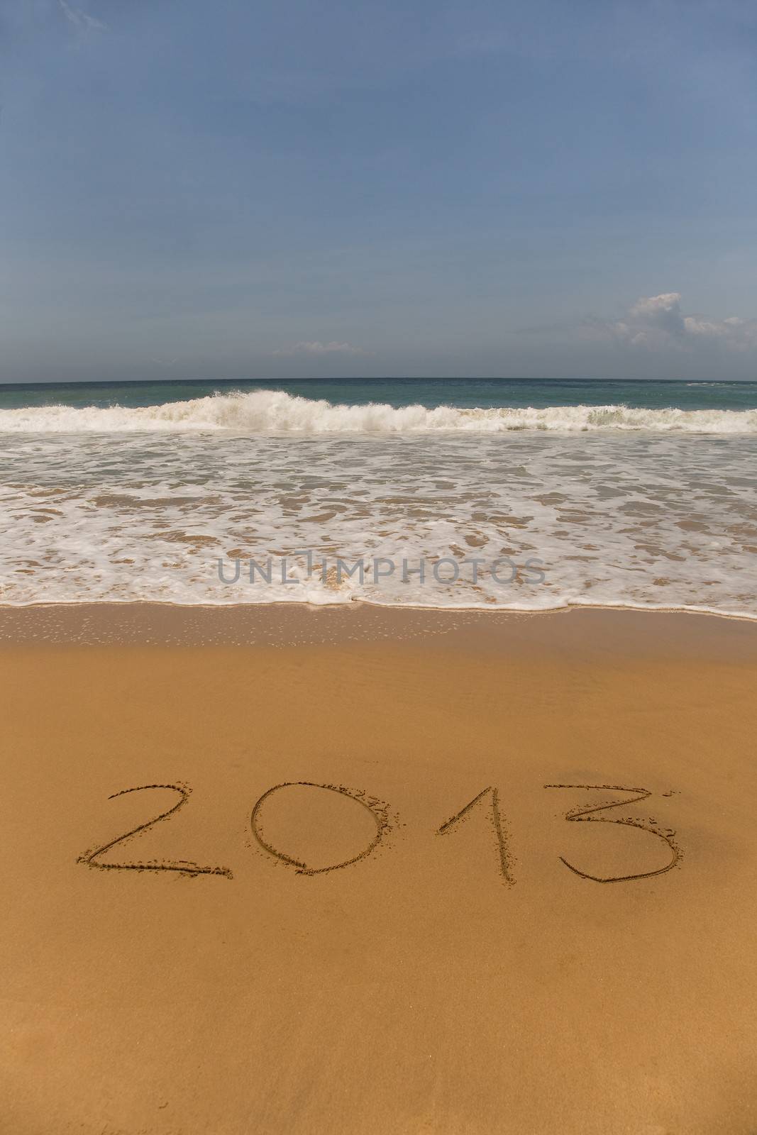 2013 written in sand on beach with sea waves 