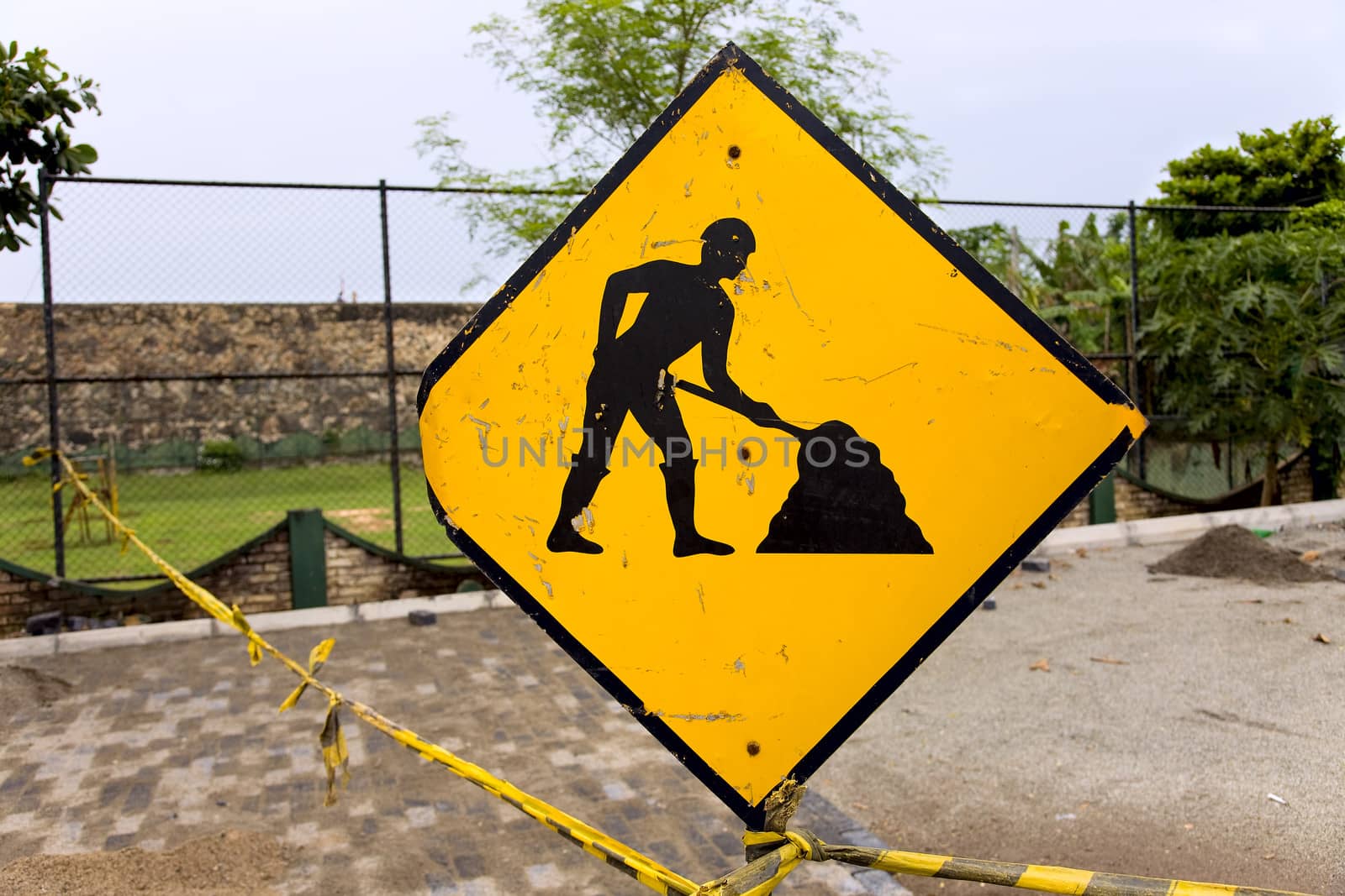 Yellow working men  - sign  about repair  road in fort Galle, Sri Lanka