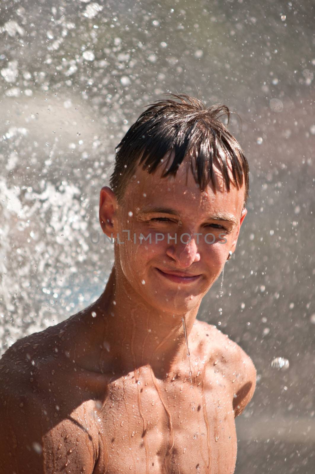 Teenager in a spray of water. by LarisaP