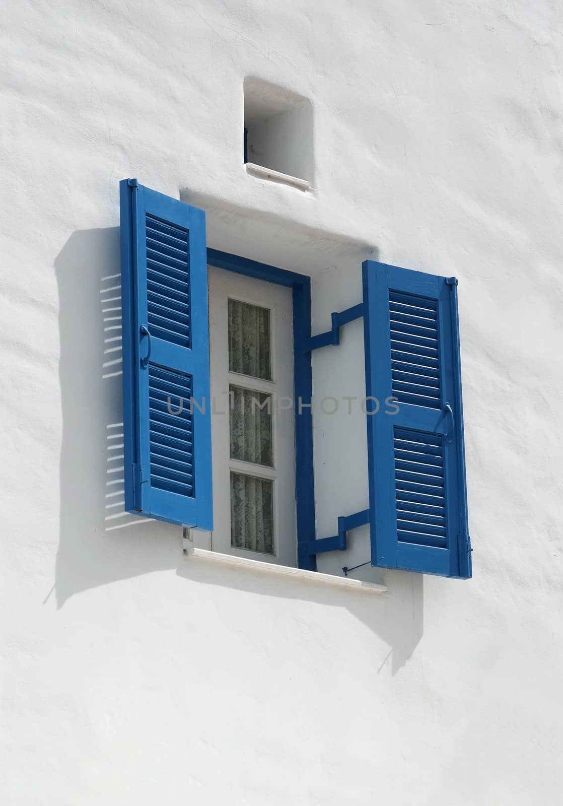  blue window on the white wall  by opasstudio