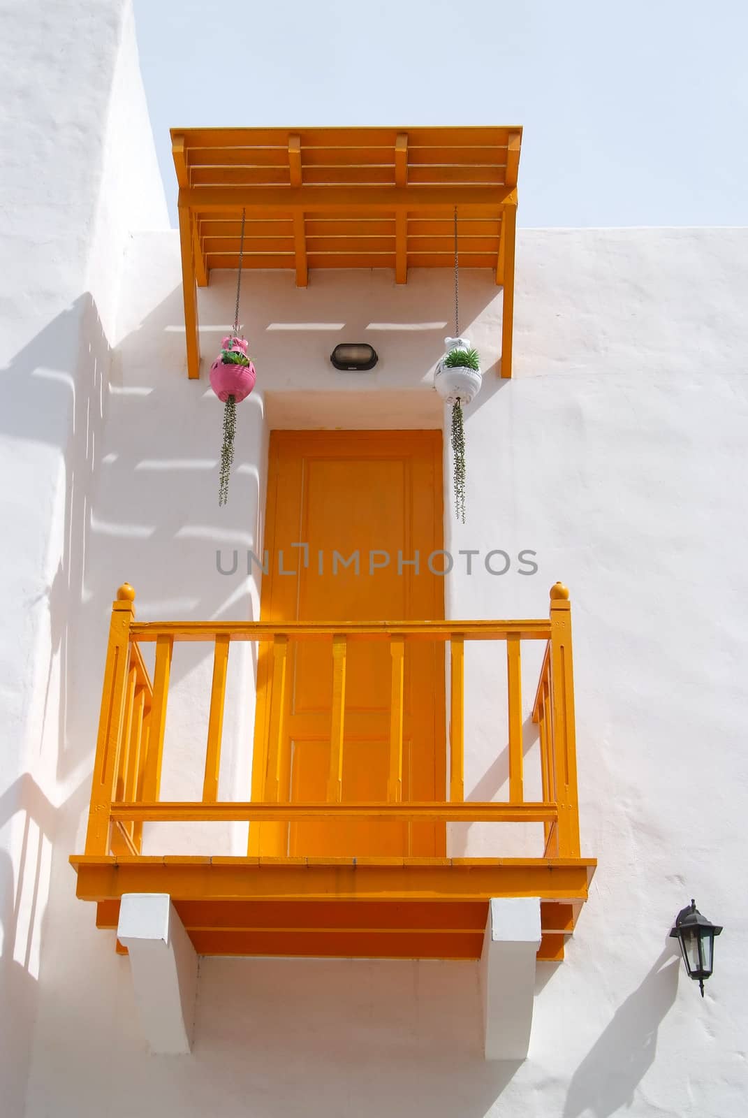 Greek style yellow door and terrace on the white wall