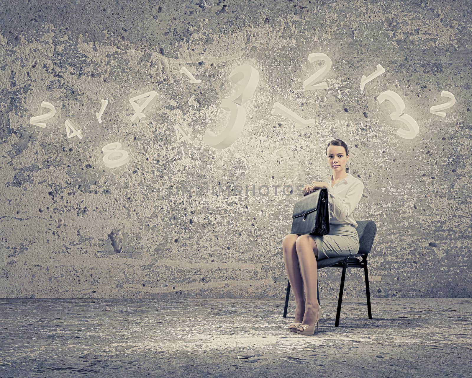 Image of businesswoman sitting on chair with suitcase in hands