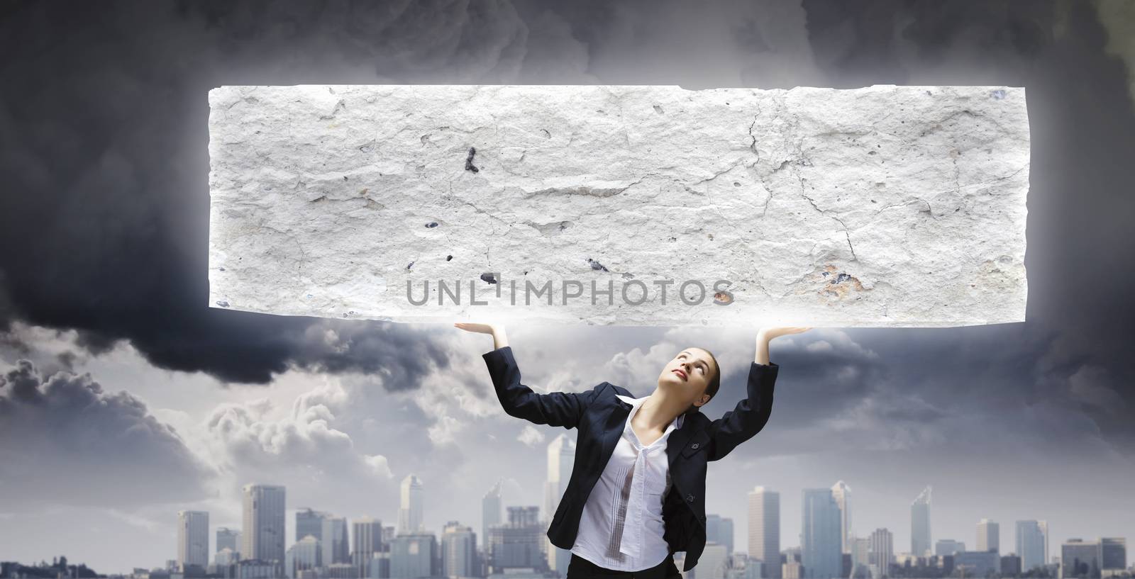 Image of young businesswoman holding burden above head