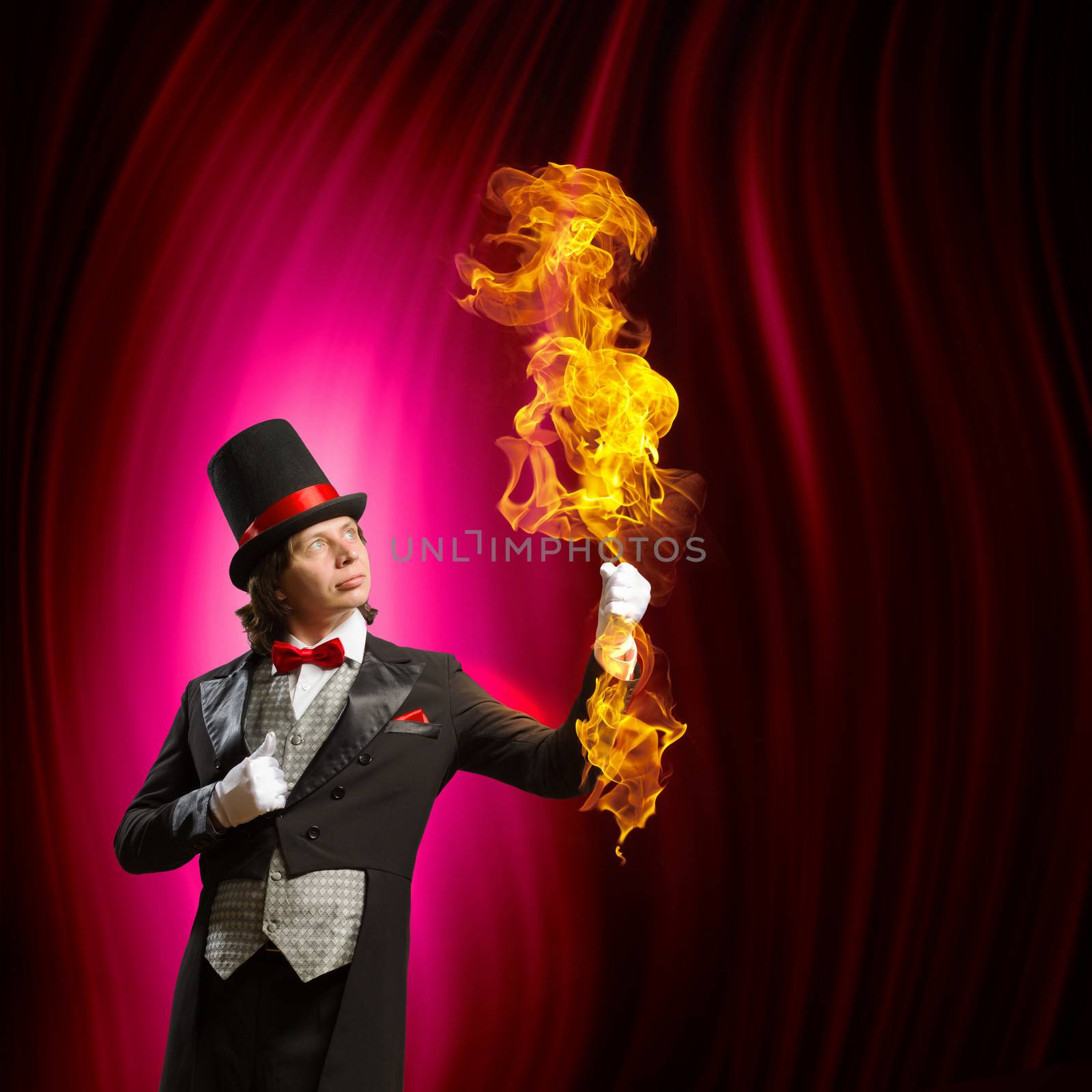 Image of man magician showing trick against color background