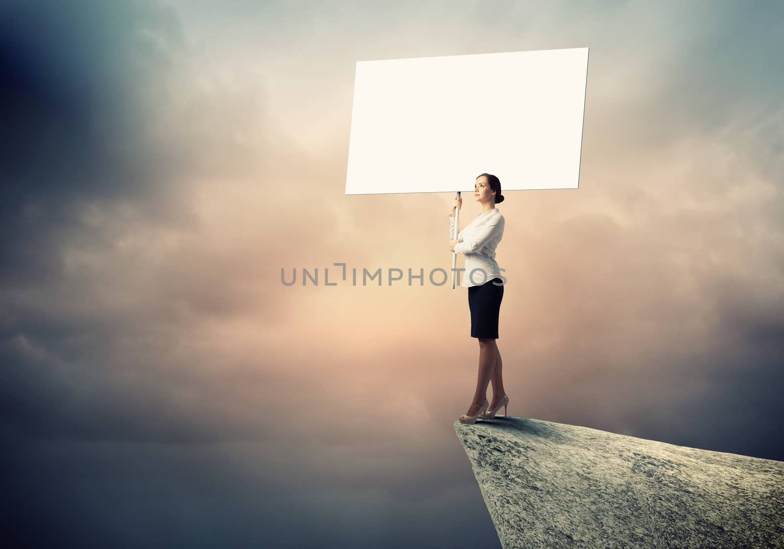 Image of business woman standing atop of hill holding blank banner