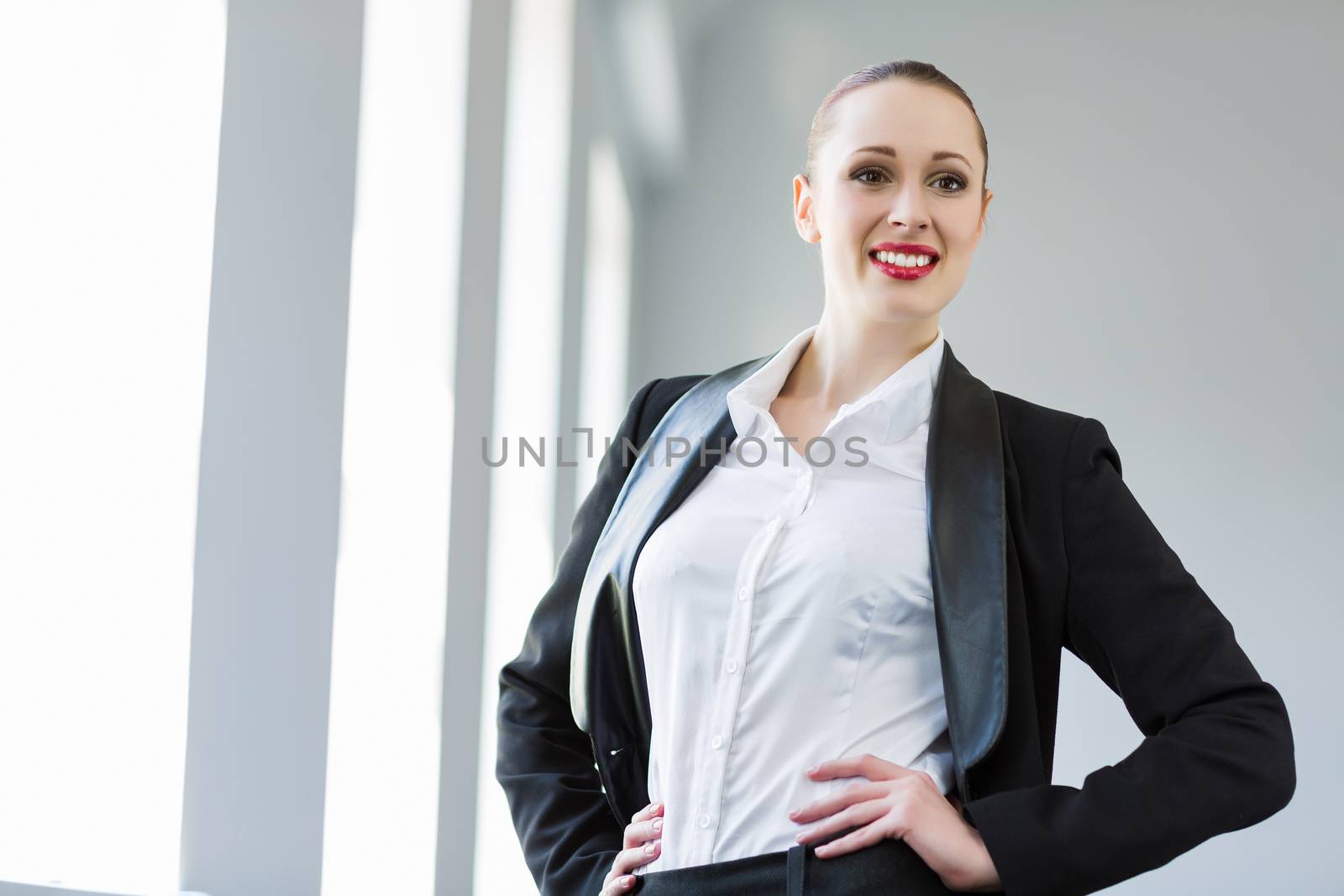 Image of young attractive businesswoman in business suit smiling