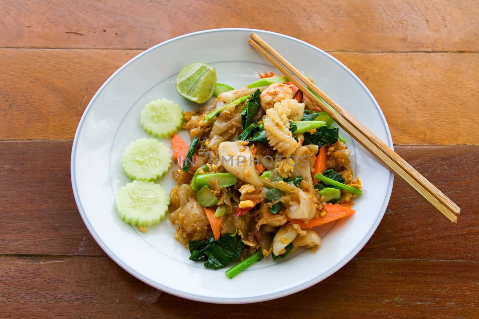thai noodle with seafood on white plate with chopsticks