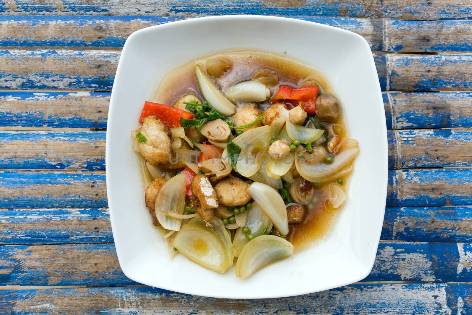 fried   vegetables with fish on white plate on the table