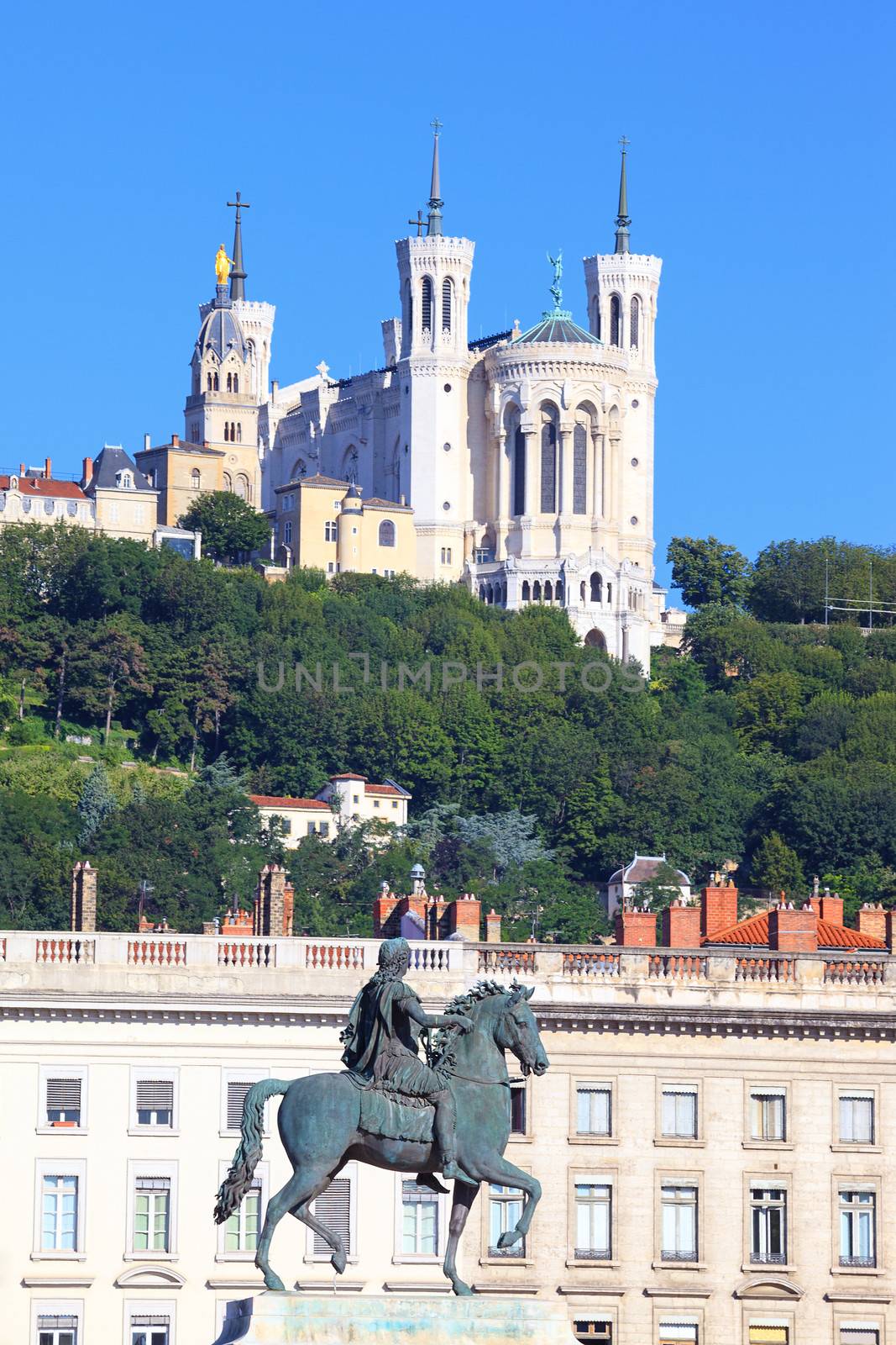 Statue of Louis XIV and basilica in Lyon city 