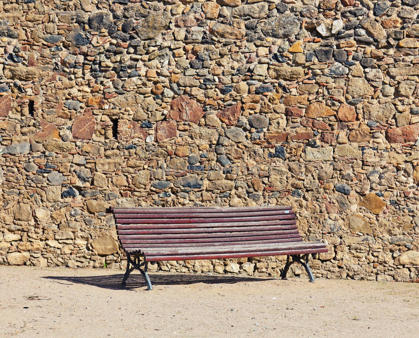 vintage bench near stone wall