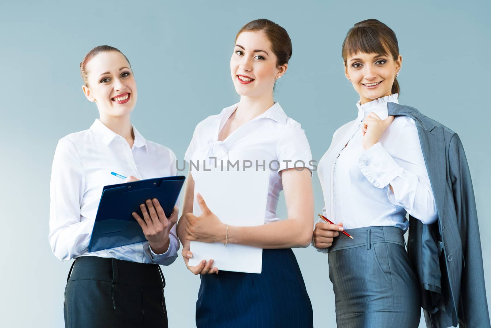 three business women standing in a row and smiling, teamwork in business