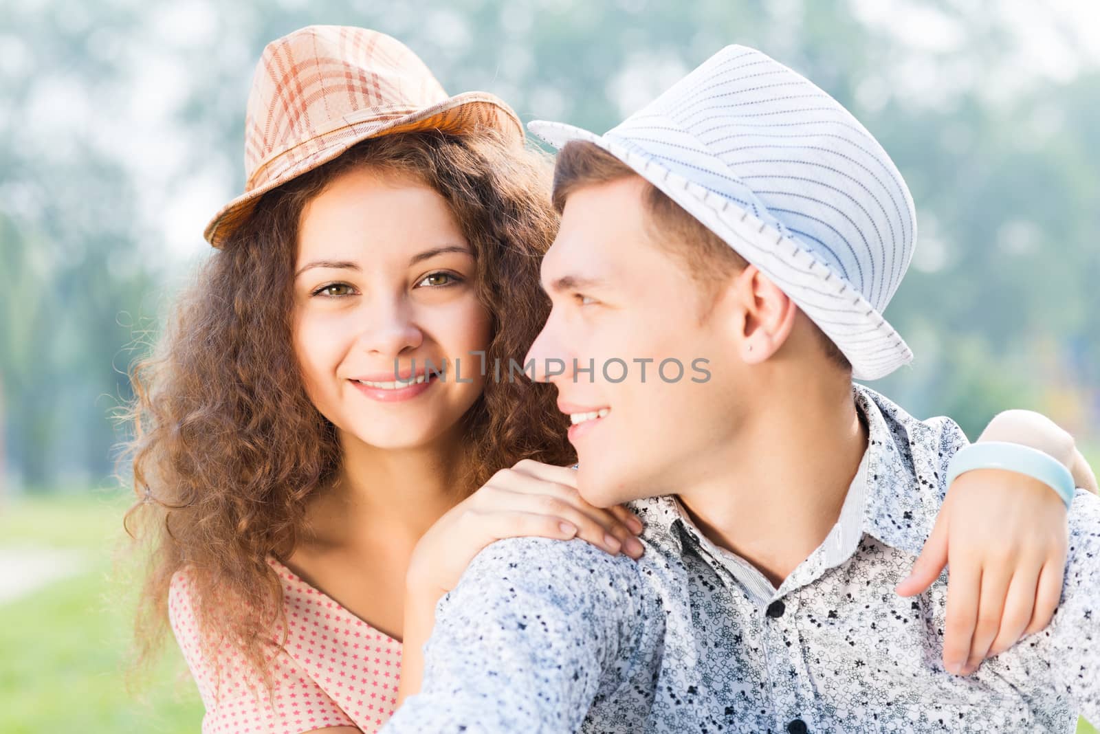 romantic couple lying on the grass in the summer park, spending time with loved ones