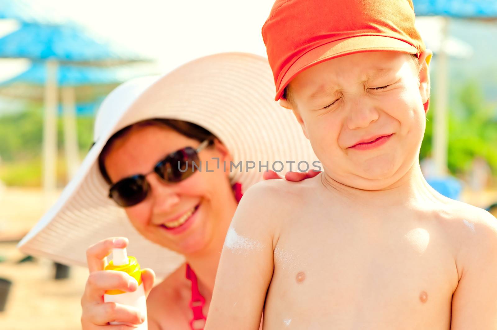 Mom puts on the baby's skin lotion for sun protection by kosmsos111