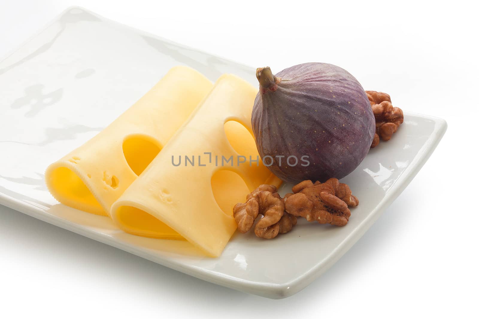 Two pieces of cheese with fig and walnut on the plate