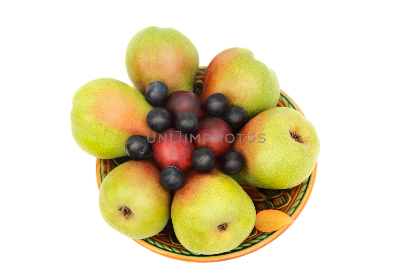 Large ripe pears, plums on a ceramic plate. Presented on a white background.