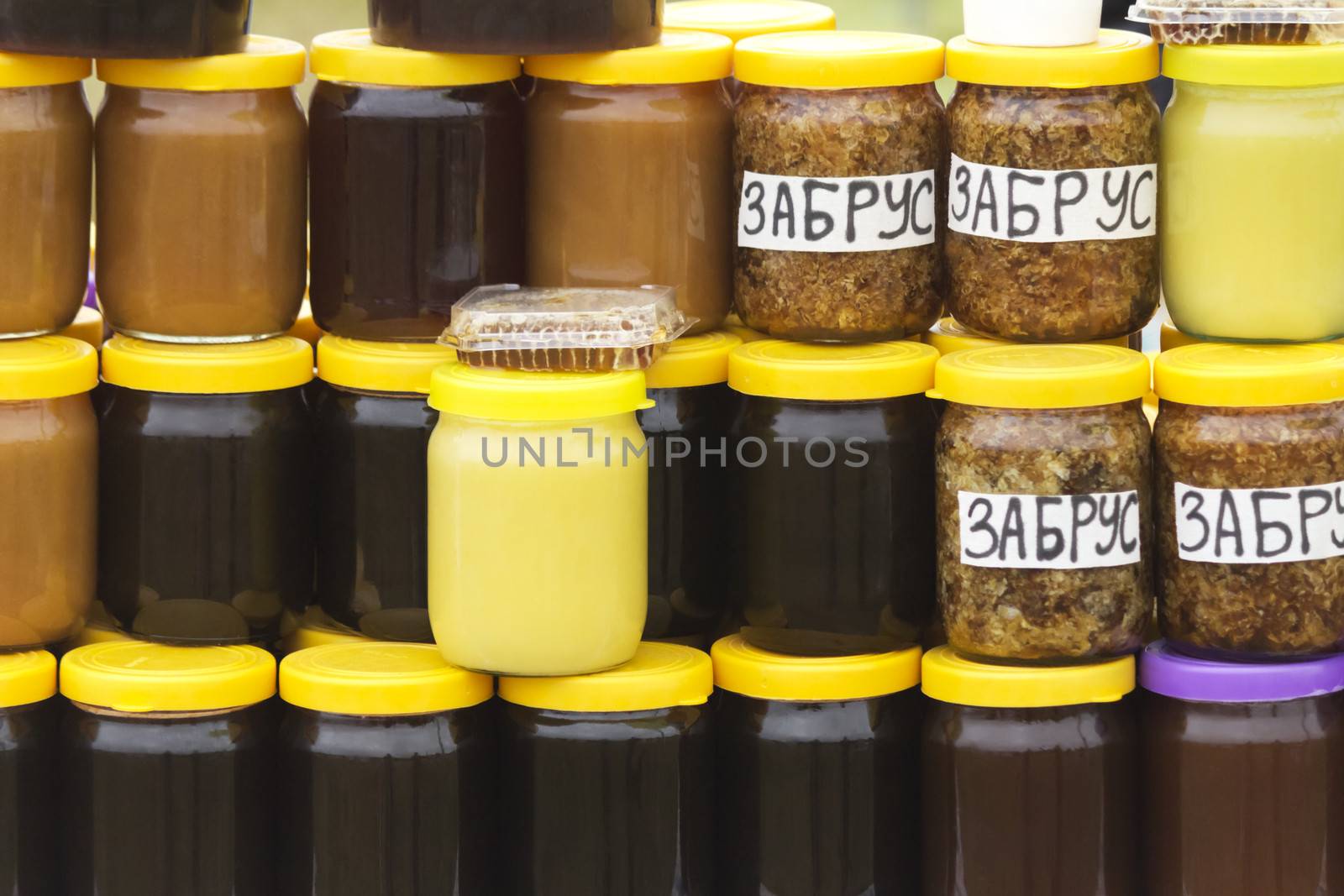 Different varieties of honey in banks, offered for sale at the f by georgina198