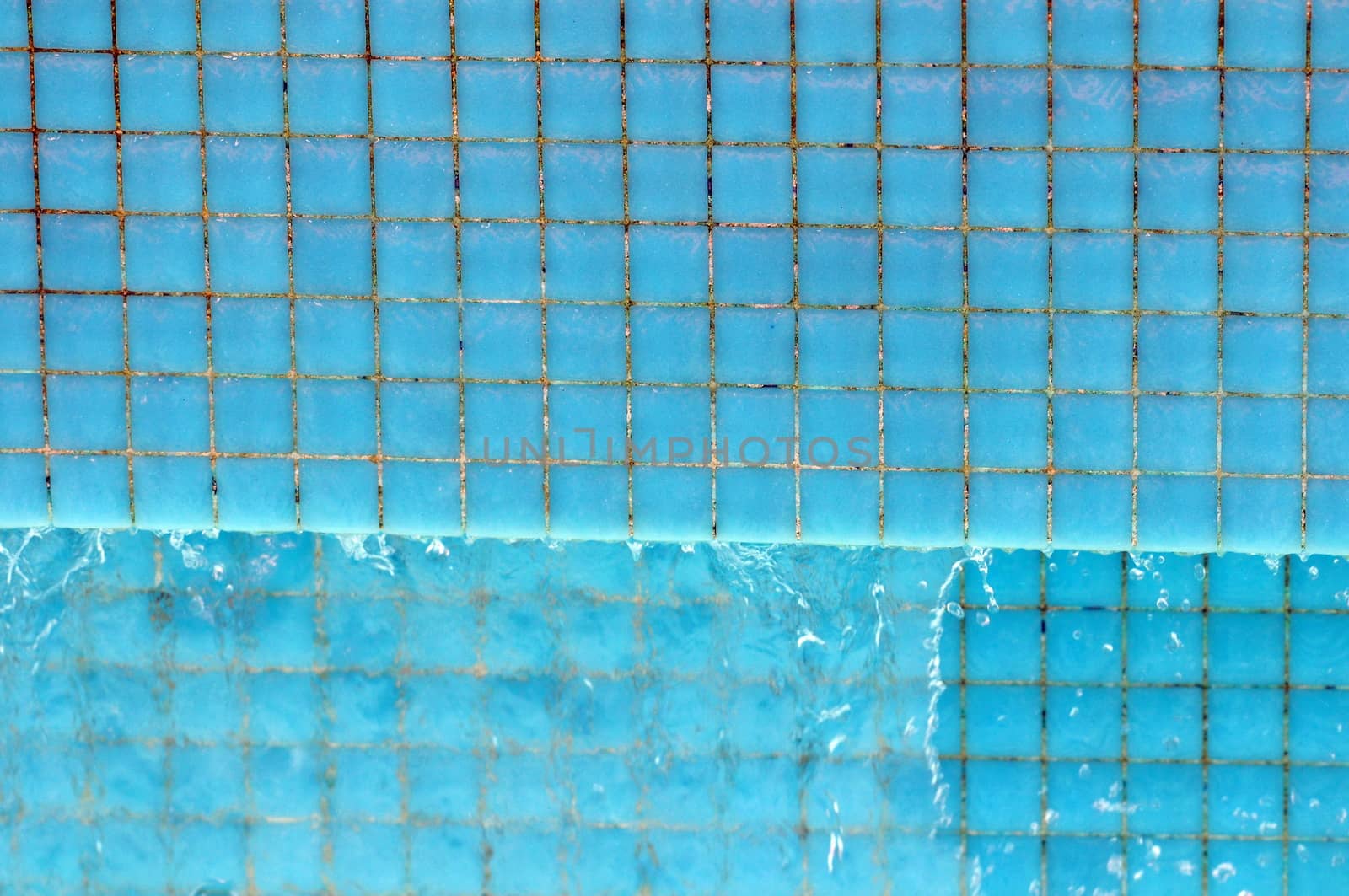 Some Water Dropping off a Blue Swimming Pool