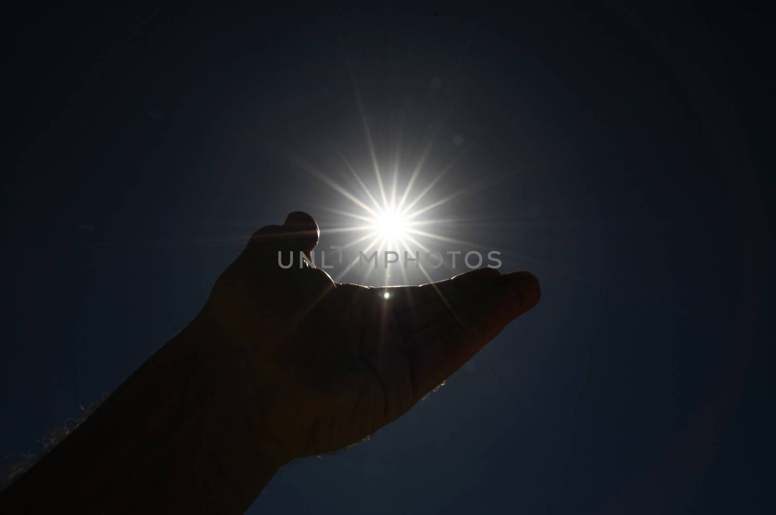 One Hand Catching the Sun Stars on a Blue Background