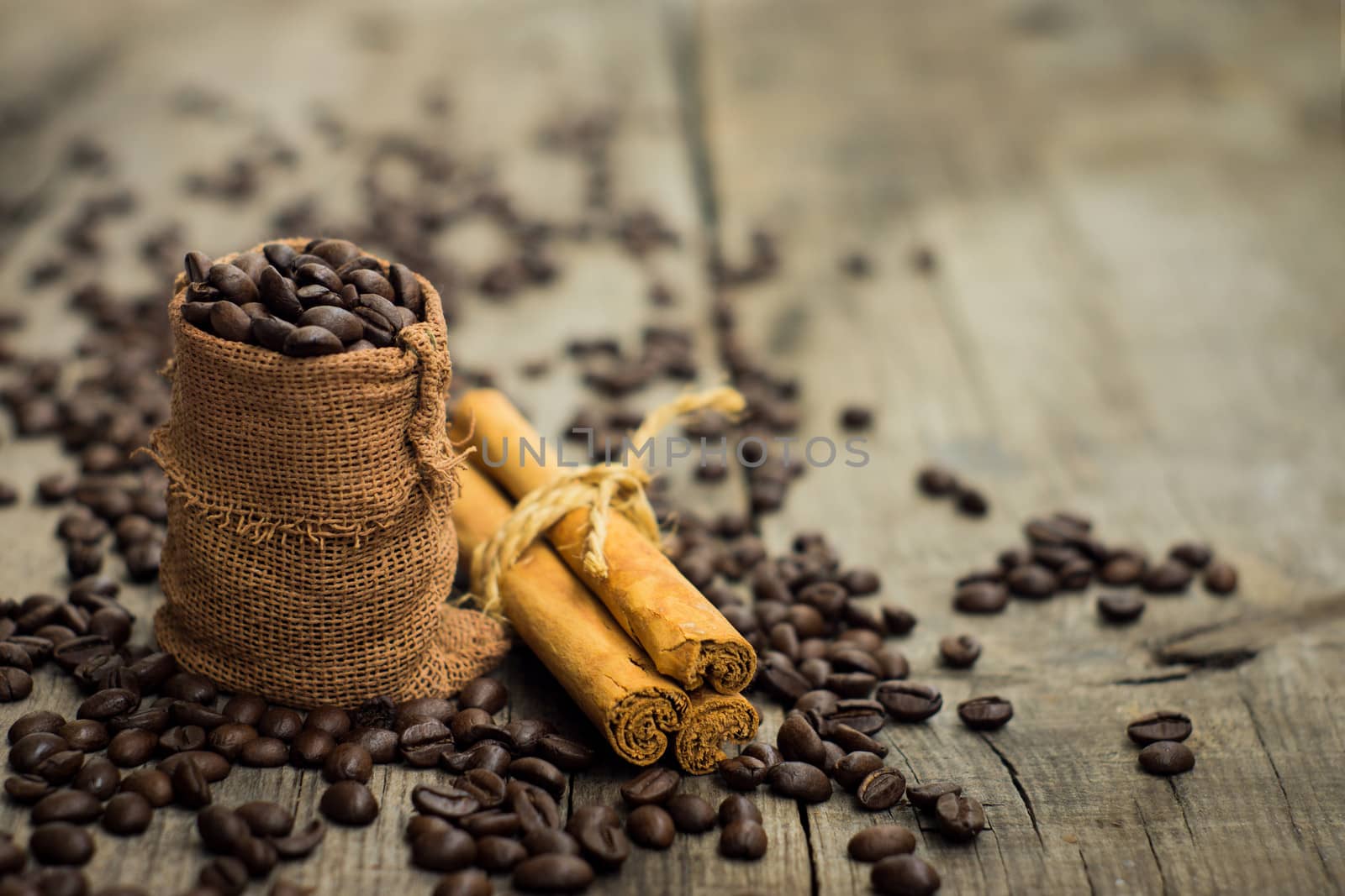Coffee beans with a cinnamon on wooden textured background