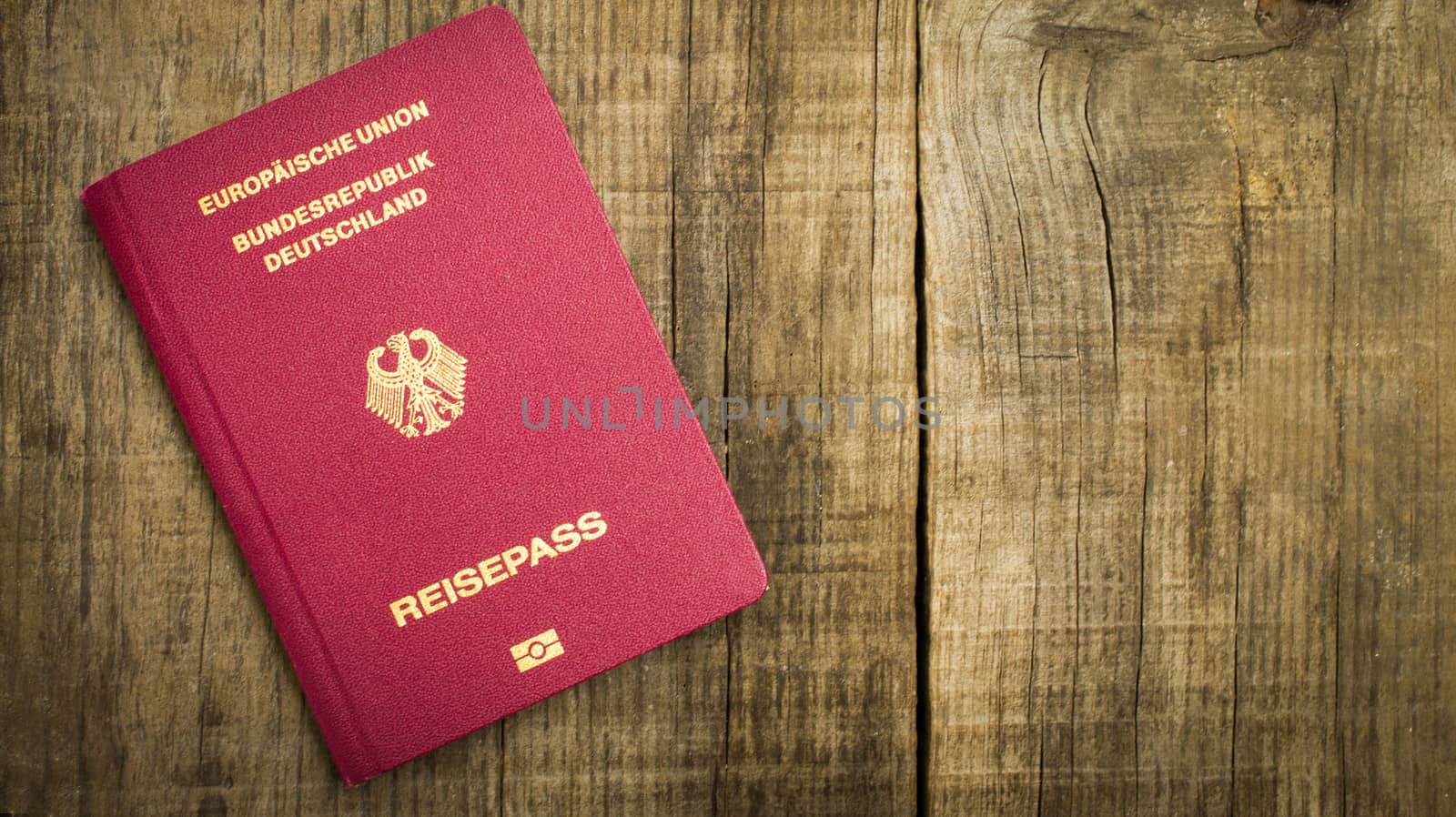 Red European Passport on wood texctured background.