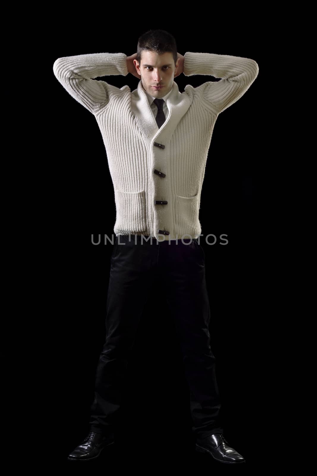 View of a young man on a relaxed pose isolated on a black background.