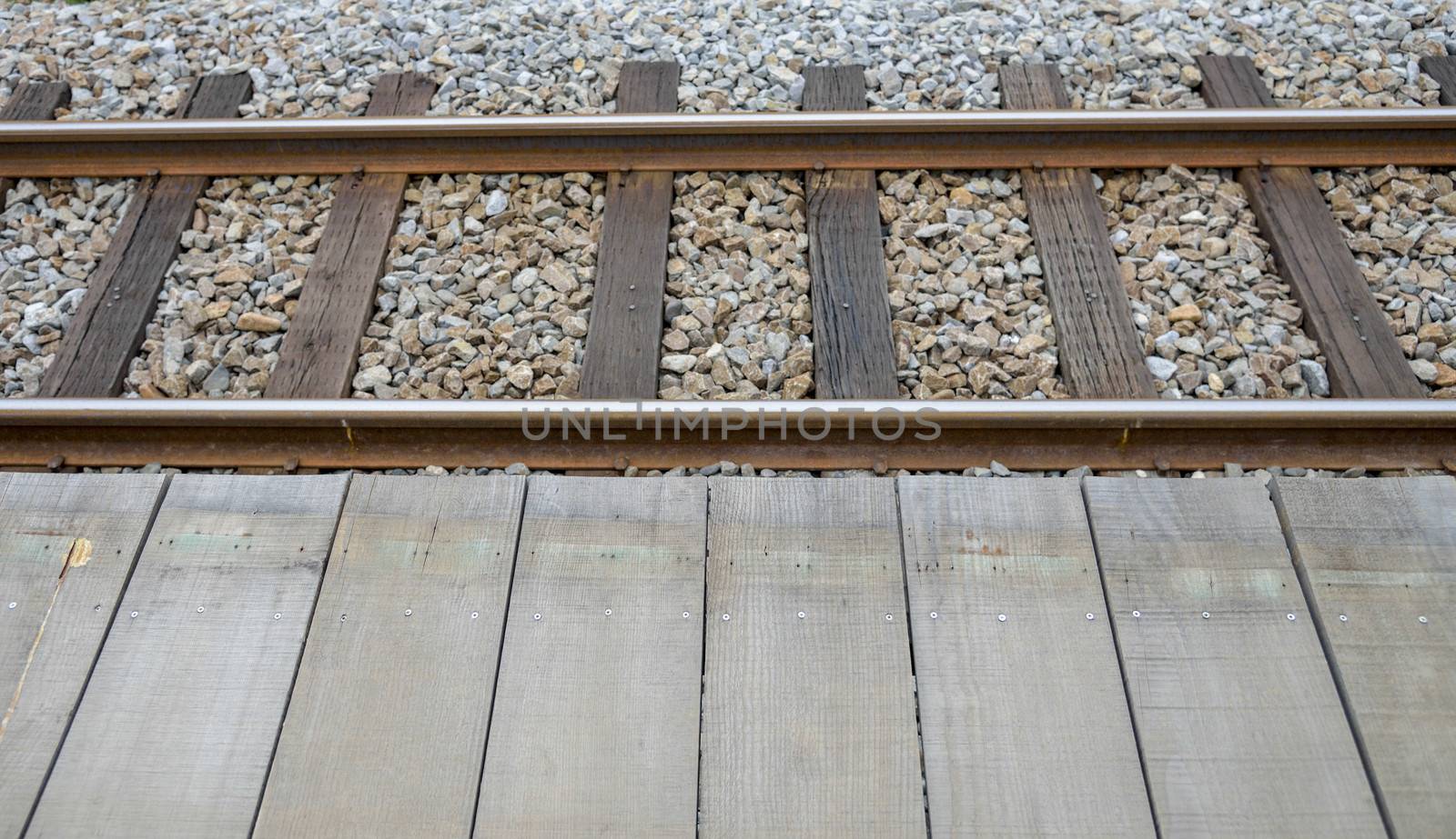 Railway and wooden platform by gjeerawut