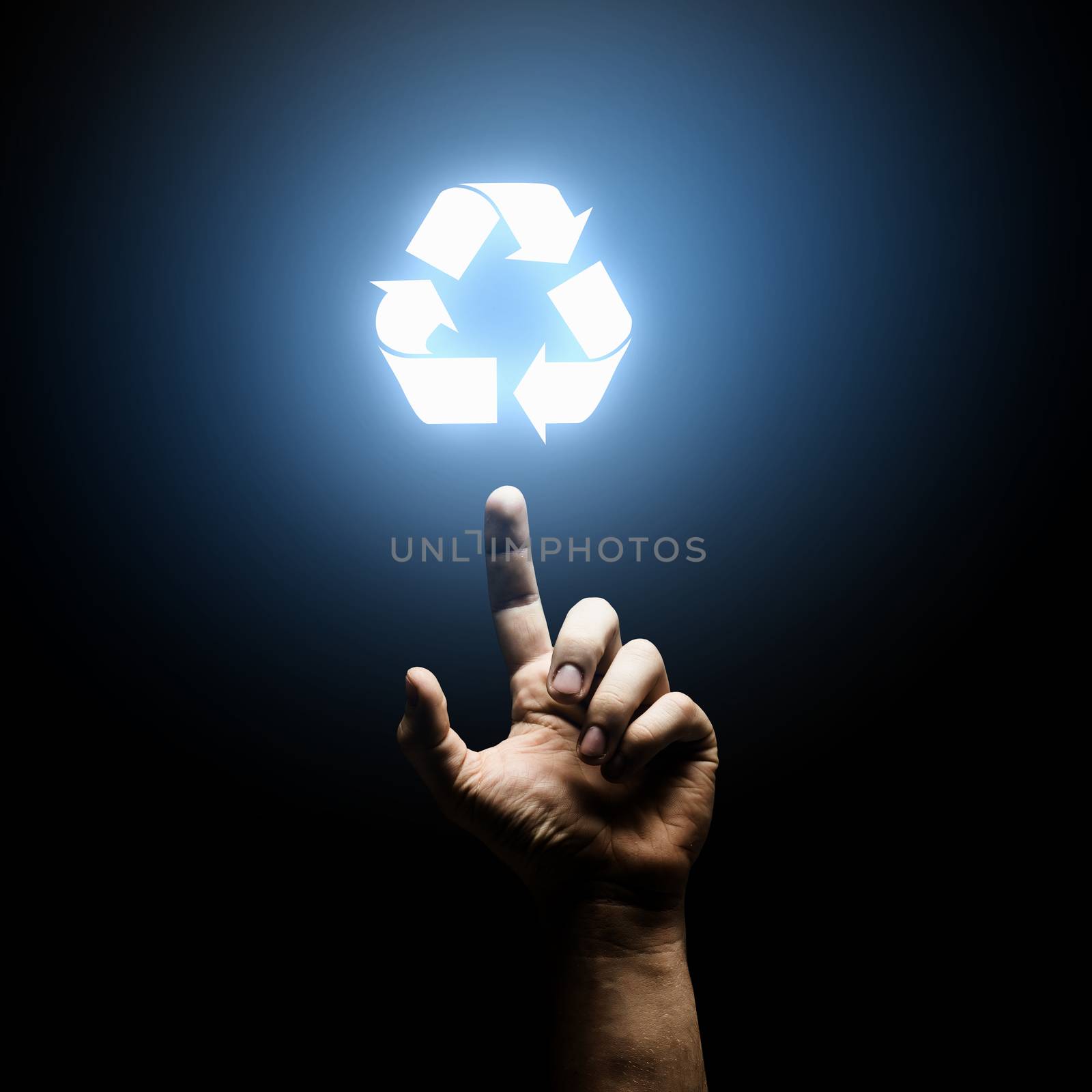 Human hand pointing with finger at recycle symbol