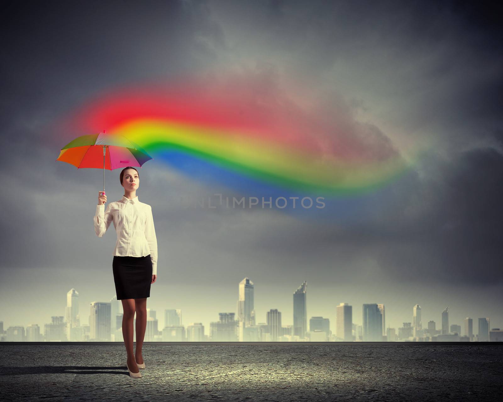 Young business woman in suit standing and holding an umbrella