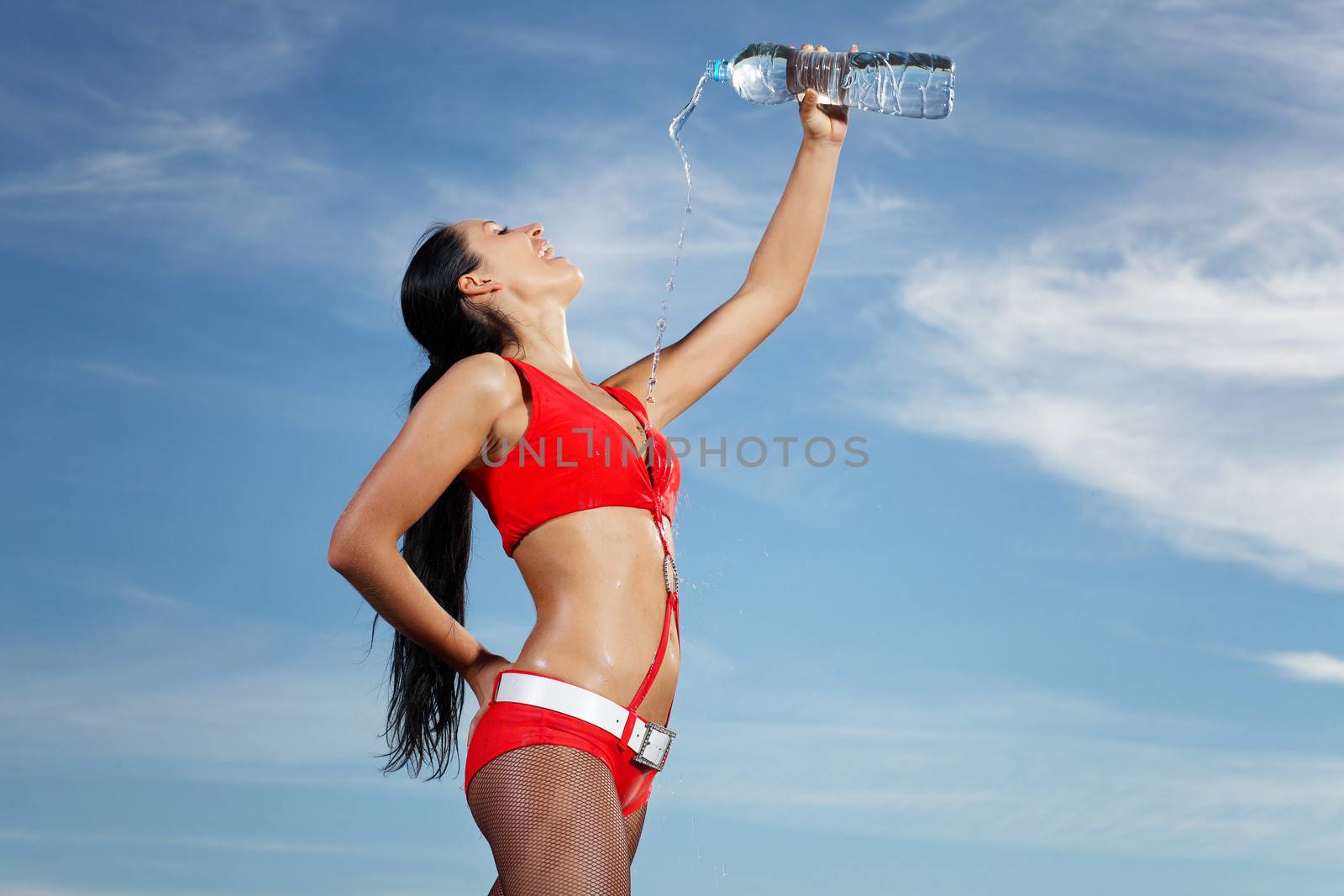 Young female sport girl in red uniform with a bottle of water