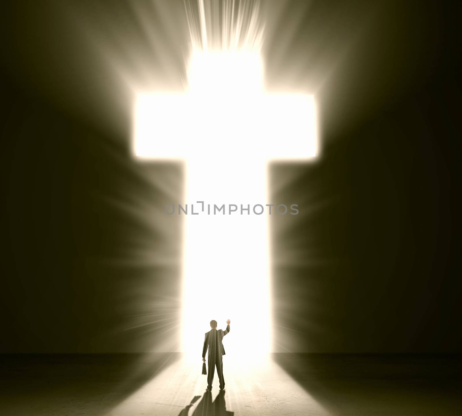 Silhouette of businessman against cross in light