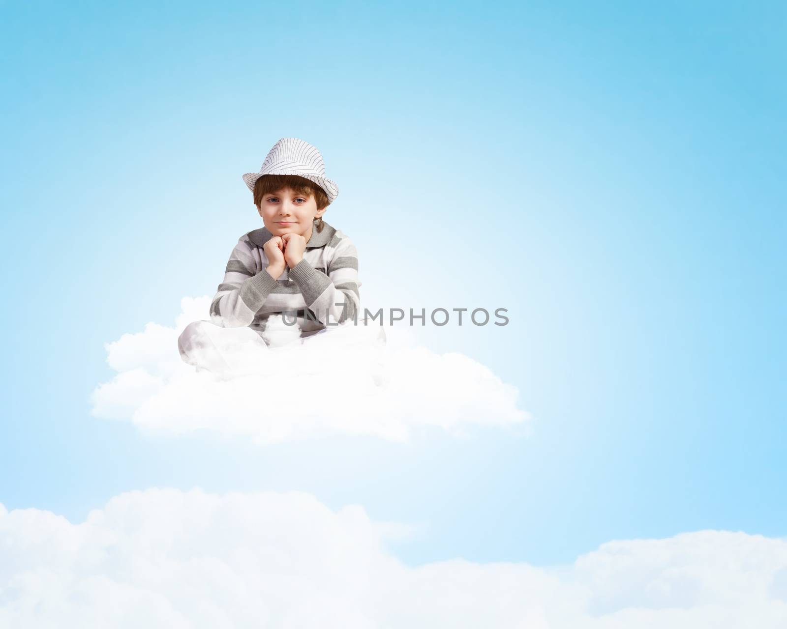 Image of little cute boy smiling sitting on clouds
