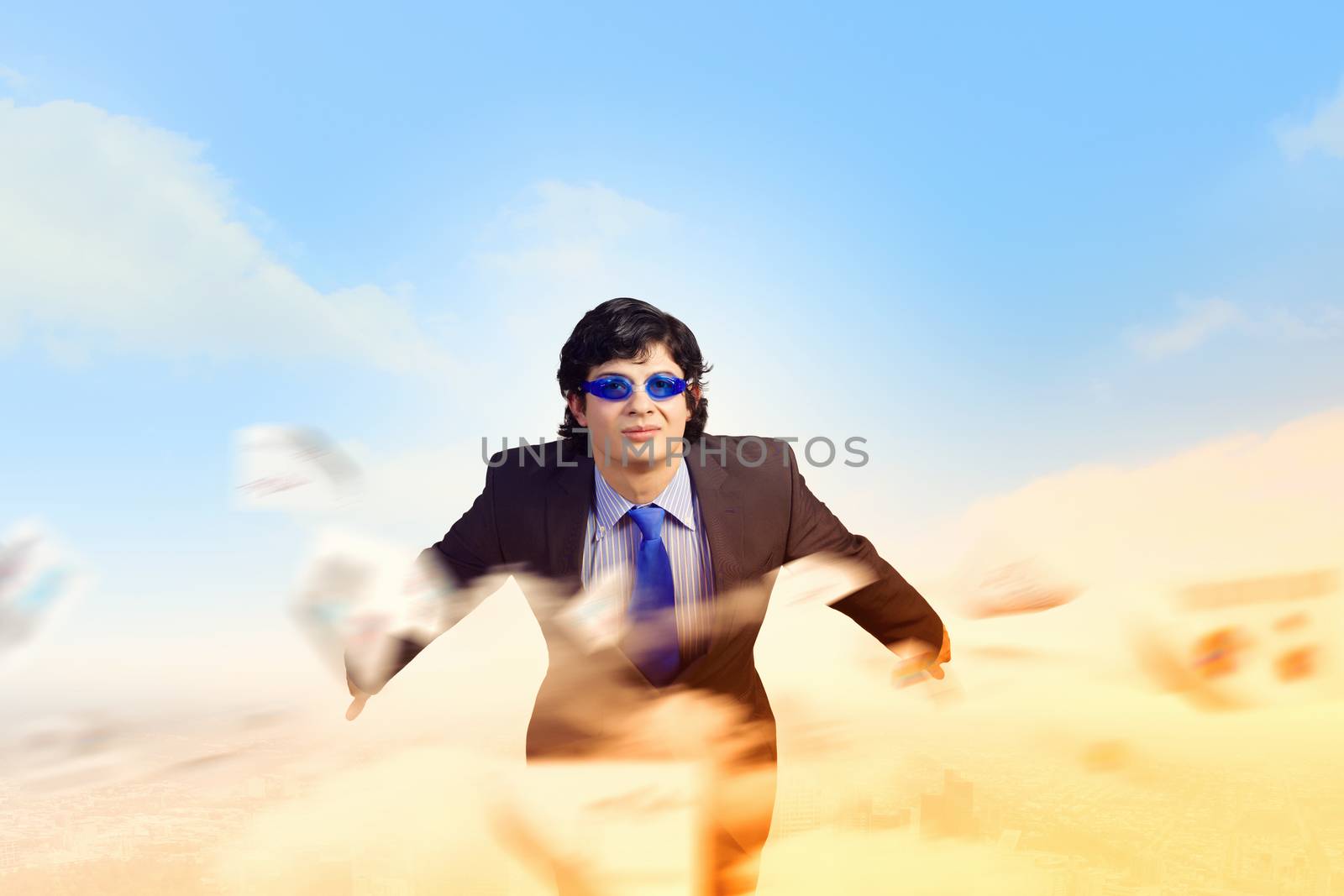 Image of young businessman in goggles jumping from top of building