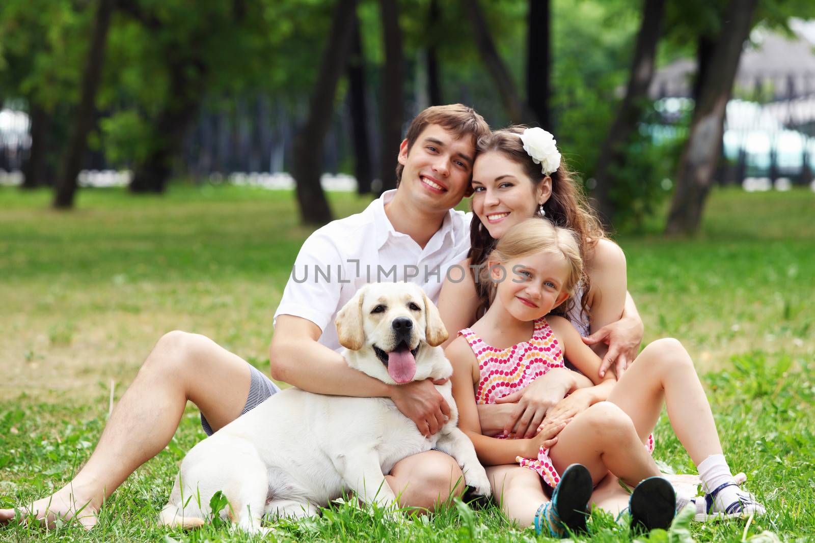 Young Family Outdoors in summer park with a dog